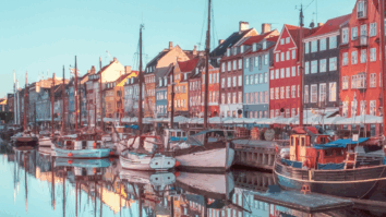 Vista do canal de Nyhavn, em Copenhague, Dinamarca, com barcos ancorados e uma fileira de prédios históricos