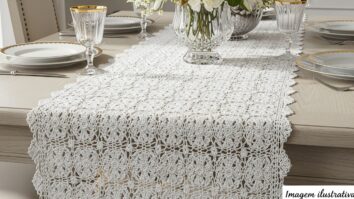 Caminho de mesa de crochê de luxo branco com detalhes dourados sobre mesa elegante de jantar, com a frase “imagem ilustrativa” no canto inferior direito.