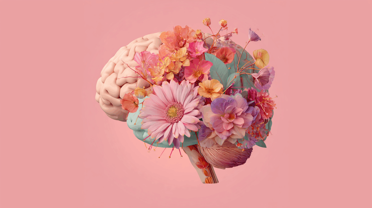 Ilustração de um cérebro em fundo rosa com flores coloridas brotando dele, simbolizando o florescimento da mente e a reprogramação de pensamentos positivos.